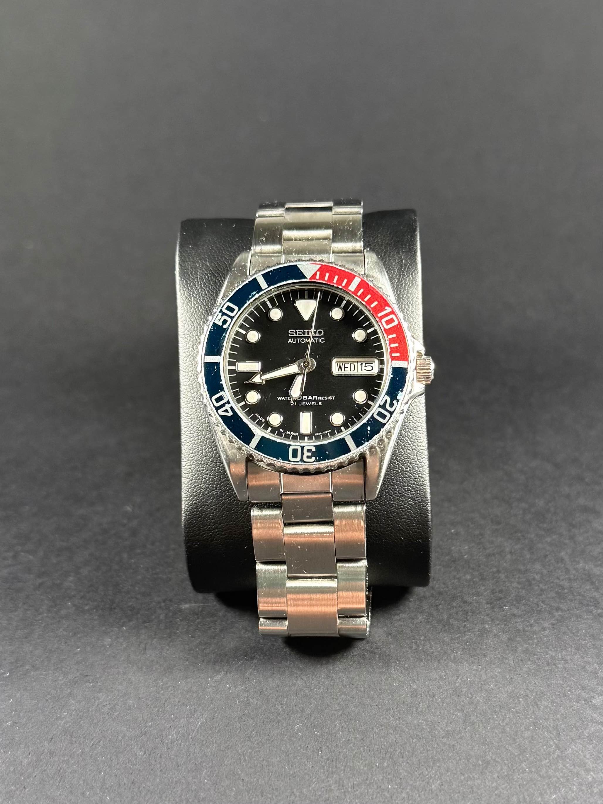 Seiko SKX025 vista frontal, esfera negra, bisel giratorio, resistente al agua